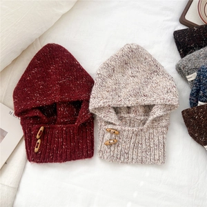 Detail of knitted balaclava with wooden buttons and warm textured winter fabric
