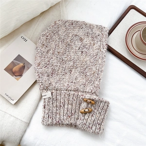 Close-up of thick oatmeal knit balaclava featuring wood horn buttons and rib texture