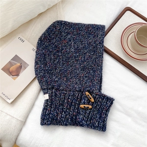 Close-up of knit texture with wooden buttons and colorful threads on a winter balaclava