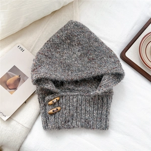 Detail of grey knitted hooded scarf featuring vintage wooden buttons and chunky knit texture