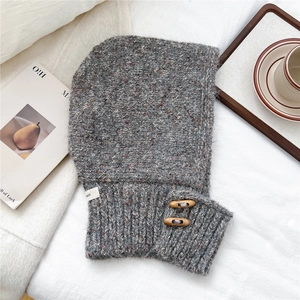 Close-up of grey knit balaclava featuring wooden toggle buttons and soft wool texture