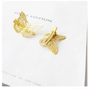 Detail view showing front and back of golden hollow butterfly hair clips with crocodile grip
