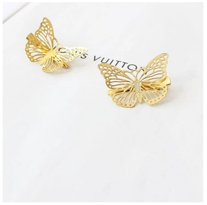 Close-up of golden hollow butterfly hair clips with intricate wing texture detail