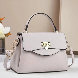 Detail of light purple pebbled leather bag with gold shield lock and top handle