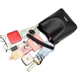 Flat lay of black bucket bag showing capacity for phone, umbrella, and cosmetics