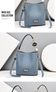 Detailed macro view of Morandi blue bucket bag with gold logo and cat pendant accessory