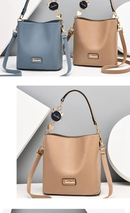 Detail shot of stylish bucket bag featuring Xilinsha metal logo and cute cat charm decoration