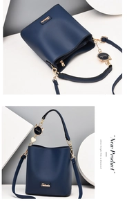 Detail of navy blue bucket bag showing spacious interior and golden cat charm
