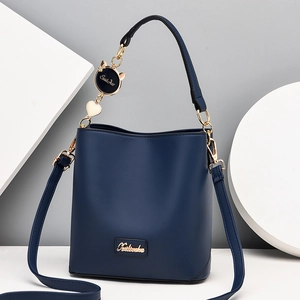Navy blue leather bucket bag with gold chain charm and adjustable crossbody strap