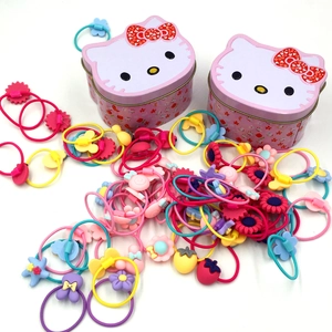Pink Hello Kitty tin boxes with colorful elastic hair ties in flower and heart shapes