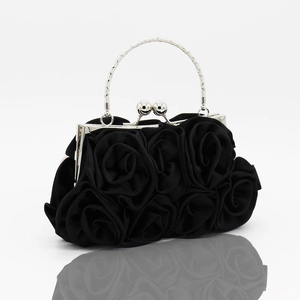 Detail of black satin evening bag featuring 3D handmade roses and silver metal handle