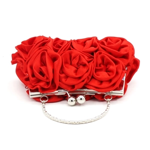 Detail of red satin clutch bag featuring handmade 3D roses and silver metal clasp