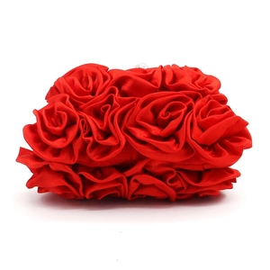 Close-up of red satin evening clutch featuring handcrafted 3D rose flower detail