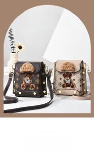 Detailed close-up of retro patterned crossbody bag with cute teddy bear embroidery and gold rivets