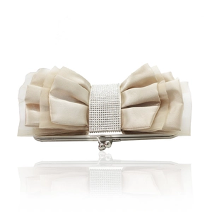 Detail of beige satin evening clutch with large bow and sparkling rhinestone centerpiece