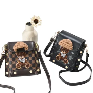 Detail of mini crossbody bags featuring bear patch and textured pattern textures
