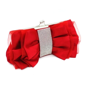Close-up of red satin evening clutch bag featuring a large bow and rhinestone center piece