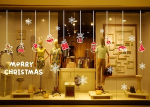 Storefront window display featuring red and white Christmas stickers with Santa and reindeer