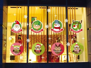 Detailed Christmas window decals featuring Santa, Reindeer, and Owls on a store display
