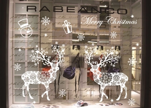 Close-up of festive Merry Christmas window stickers decorating a leather handbag display