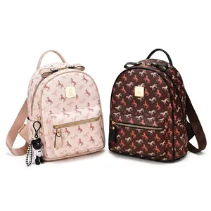 Close-up of printed pebble leather backpacks with bow decor and doll keychain
