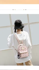 Detail view of pink small backpack with pony prints and a cute bear charm on model