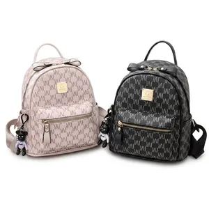 Détail de petits sacs à dos en similicuir avec nœuds décoratifs et pendentifs d'ours