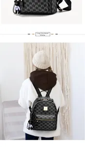 Détail d'un grand sac à dos noir à monogramme avec zip doré et charmant pendentif ours