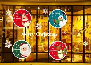 Detailed view of Christmas window stickers with elk and snowman on a warm shop glass window