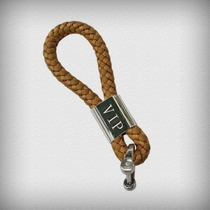Macro shot of brown braided leather keychain with VIP engraved silver metal connector