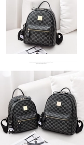 Détail du sac à dos noir monogrammé avec poignée à nœud et pendentif ours mignon rayé