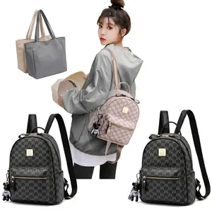 Vue détaillée des mini sacs à dos avec motifs monogrammes et breloque ours en beige et noir