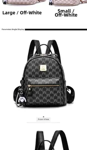 Détails d'un grand sac à dos noir en cuir synthétique avec motifs lettres et breloque ours