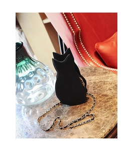 Close-up of a stylish black cat-shaped crossbody bag with a golden chain strap