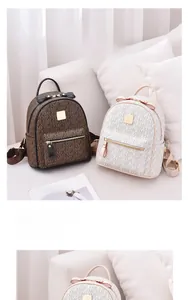 Detail of two mini backpacks in brown and beige PU leather with letter prints