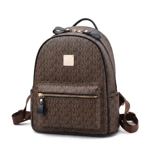 Close-up of brown faux leather backpack featuring letter prints and a gold metal logo plate