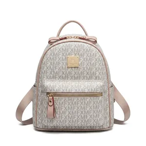 Outdoor shot of a woman wearing a grey monogram mini backpack with pink straps