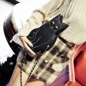 Detail of a chic black cat-shaped crossbody bag with white stitching and leather metal chain