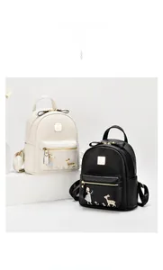 Détail de broderie fille et cerf sur des sacs à dos en cuir à texture litchi