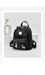 Détail d'un sac à dos noir en cuir grainé avec broderie fille et cerf et fermetures éclair dorées