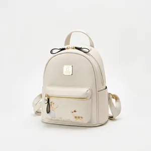 Détail du sac à dos en cuir blanc avec broderie colorée et finitions métalliques dorées
