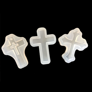 Three silicone cross pendant molds for resin casting shown on a black background