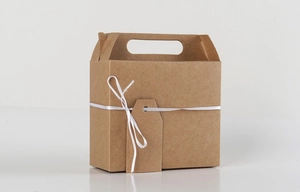 Close-up of brown kraft paper gift box featuring a white ribbon and blank hanging tag