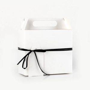 Minimalist white kraft paper gift box with black ribbon and handle on white background