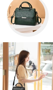 Detailed close-up showing the crocodile texture and metallic hardware of the crossbody bag