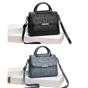Detail of elegant crocodile-embossed leather handbags with metal hardware and thin strap