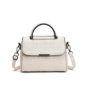 Detail view of red and white crocodile pattern crossbody bags with silver metal bars