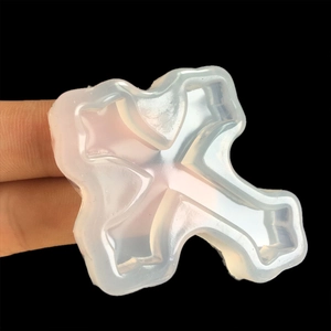 Detailed view of a flexible translucent silicone cross mold for DIY jewelry making