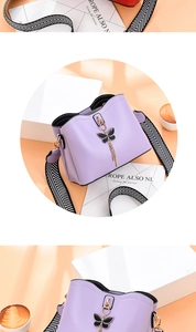 Détail du sac seau lavande avec pendentif papillon et bandoulière en zigzag