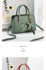 Close-up of green leather bag featuring detailed floral embroidery and butterfly charm